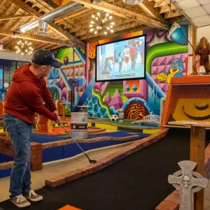 Someone putting into a mini golf holecourse