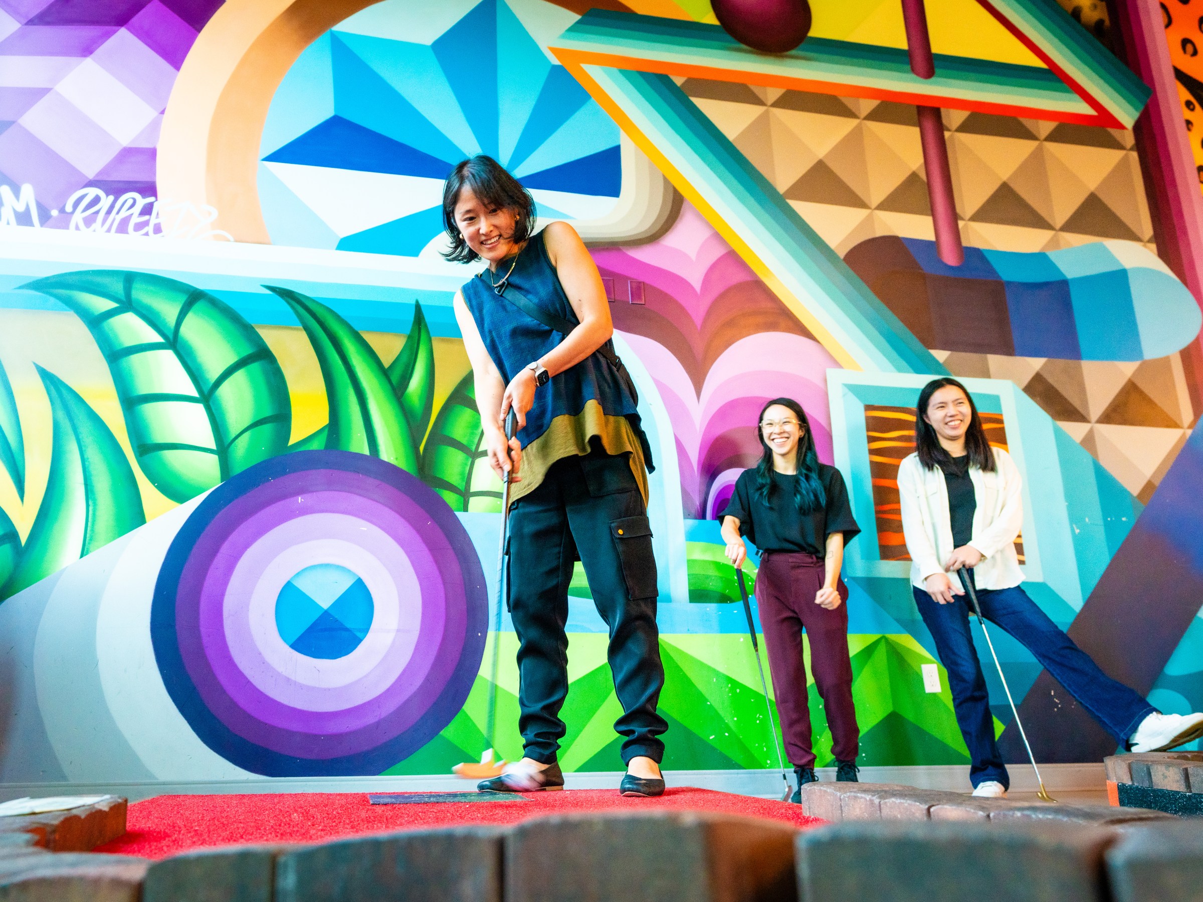 Person playing mini golf in a colorful location.