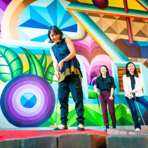 Person playing mini golf in a colorful location.