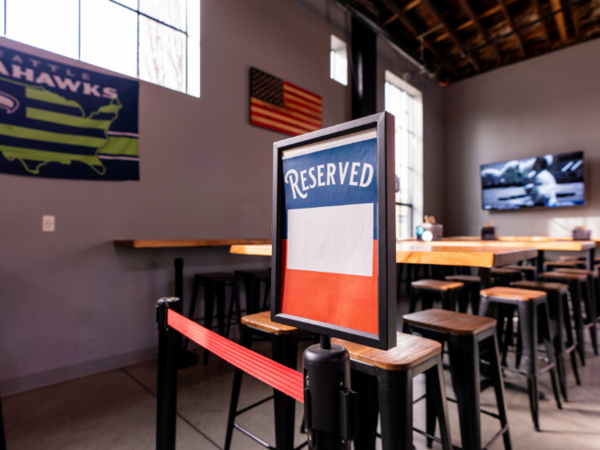 A reservation sign for a event space and tables.