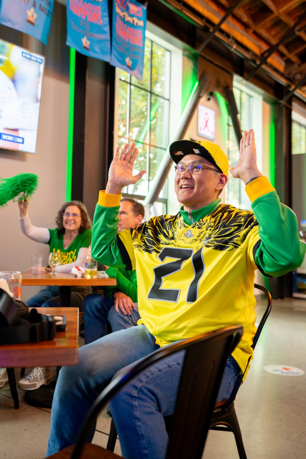 Person with arms up wearing Oregon Ducks jersey.
