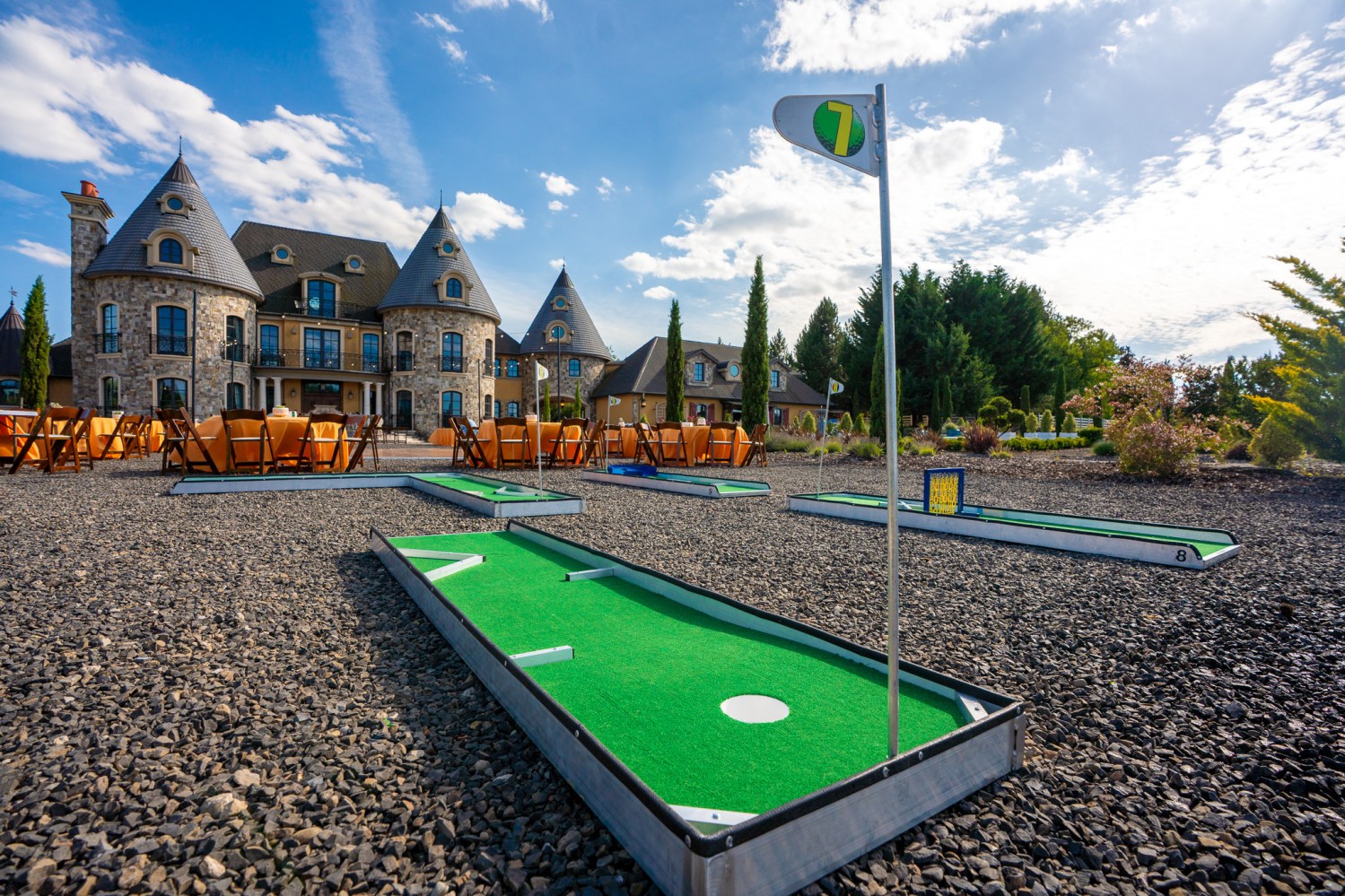 Traveling mini golf course in front of a castle building wedding venue.